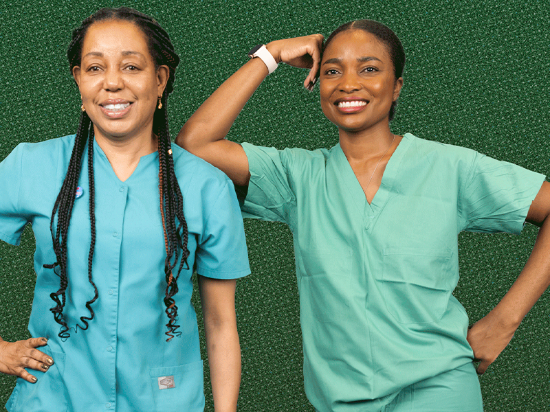 two nurses posing and smiling at the camera