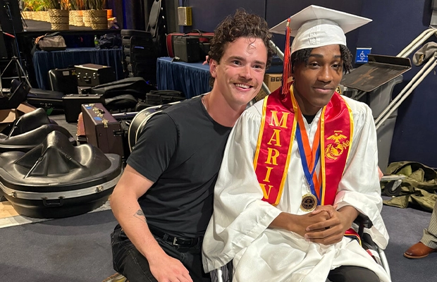 Man embracing a young person in a wheelchair