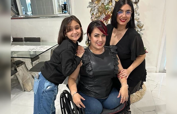 woman in wheelchair accompanied by family