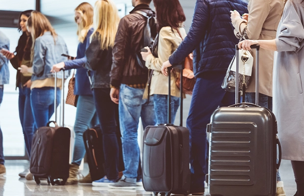 Photograph of several people queuing at the airport.