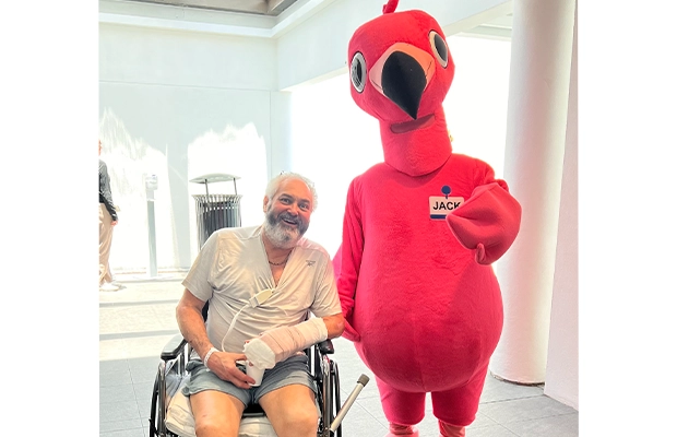 man in a wheelchair posing next to a person dressed as a red bird