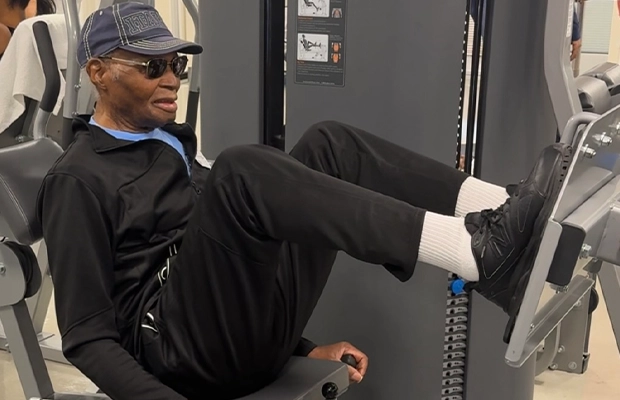 Adult man in sweatshirt and glasses exercising