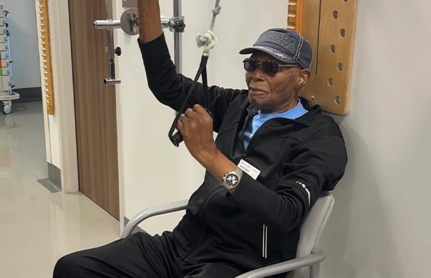 Adult man in sweatshirt and glasses exercising
