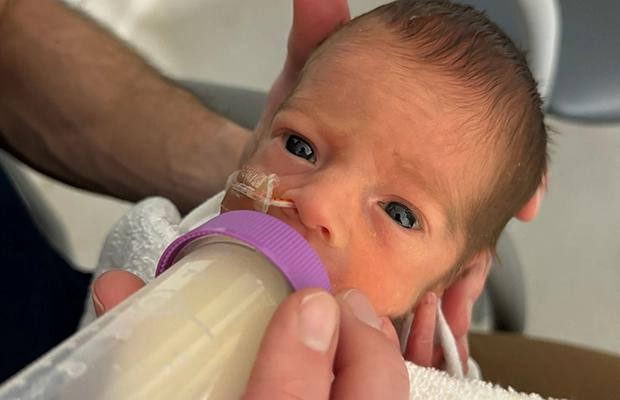 newborn drinking from a bottle
