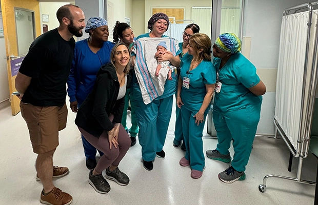 group of doctors and nurses holding a small baby