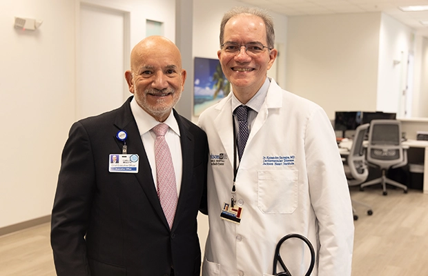 A man next to a doctor posing and smiling at the camera
