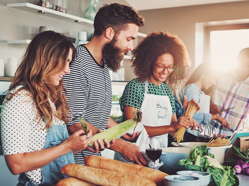 three people in the kitchen, preparing healthy food
