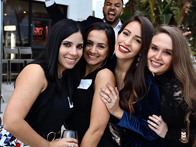 four women hugging each other smiling at the camera