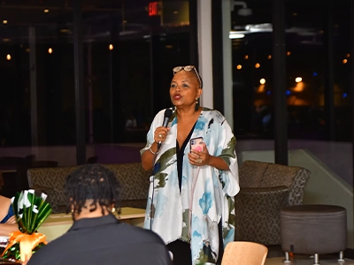 woman speaking into a microphone at a formal event
