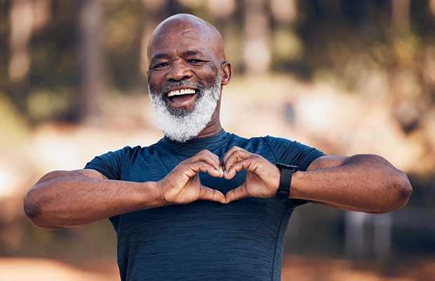adult man makes a heart sign with his hands