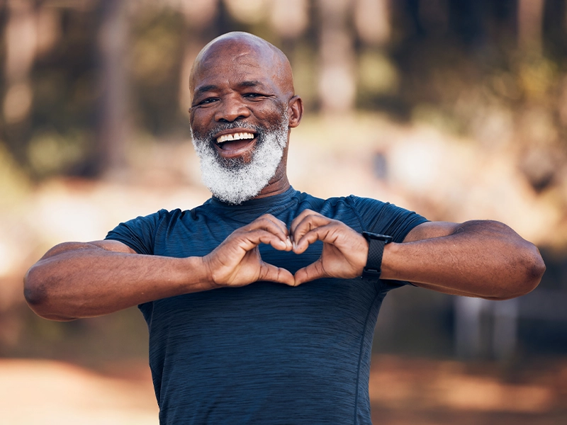 adult man makes a heart sign with his hands