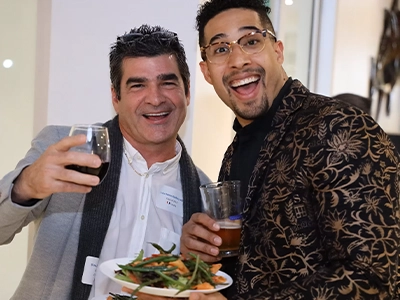 two men embracing, smiling at the camera