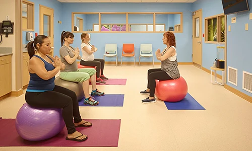 A group of women in a room sitting on yoga balls