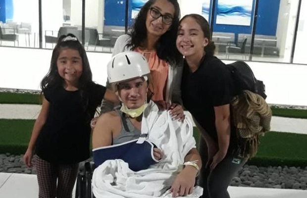 three women accompanying man in wheelchair