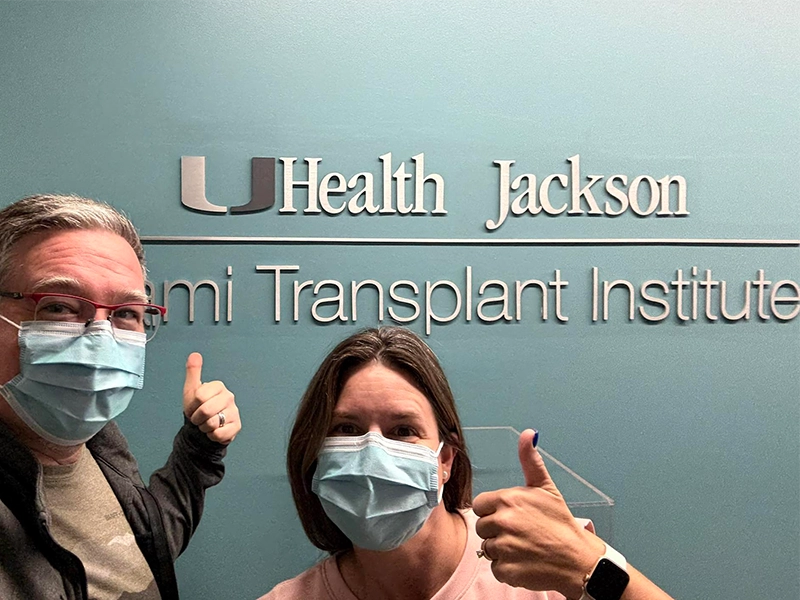 adult couple next to a Jackson Health sign