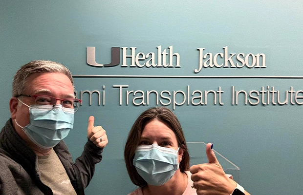 adult couple next to a Jackson Health sign