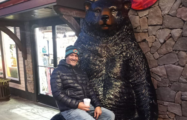 man sitting on bear monument