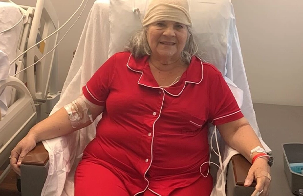woman with head bandages sitting in hospital chair