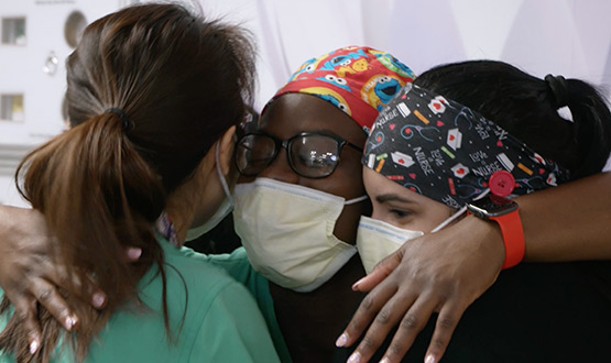 Three medical professionals hugging