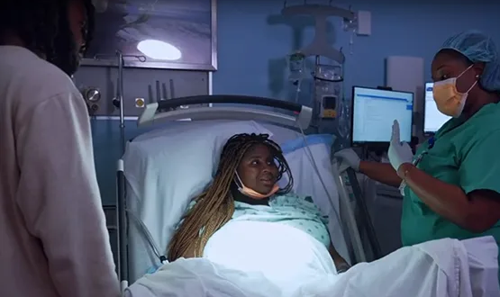 A medical professional speaking to a woman in labor, they're inside a medical room