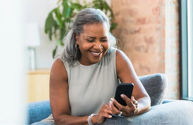 adult woman checking her cell phone while smiling
