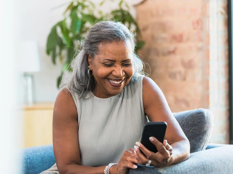 adult woman checking her cell phone while smiling
