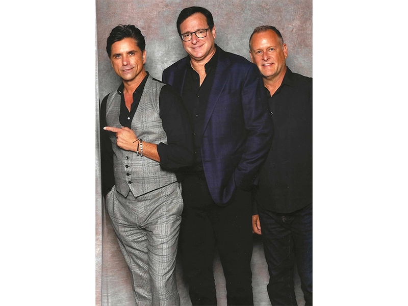 Three men in suits posing and smiling at the camera