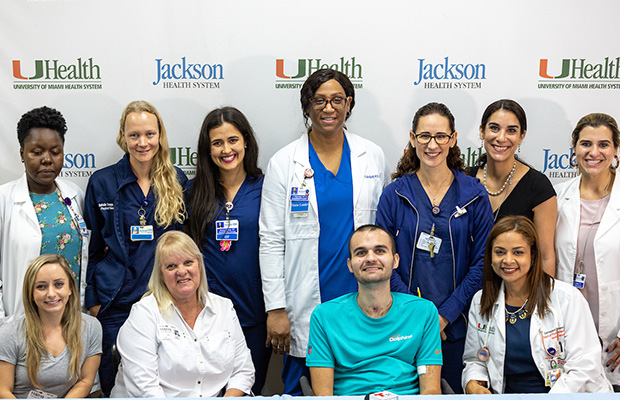 Thomas “Nicholas” Williams smiling and sitting with hospital staff
