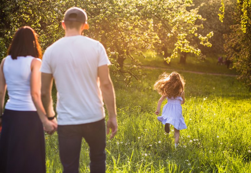 parents-looking-their-girl-child-running-park