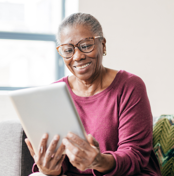 woman reading on tablet smiling