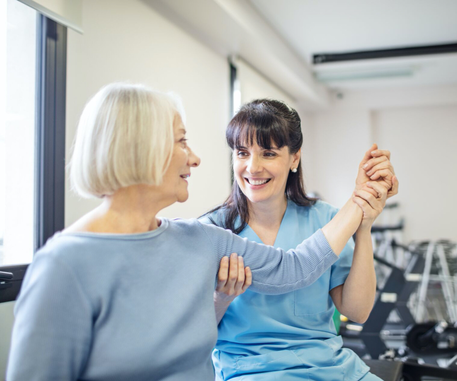 care taker helping woman in fitness center