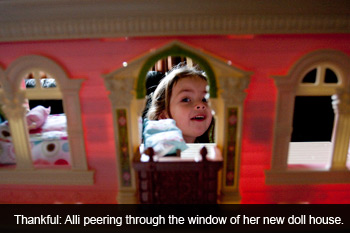 Alli peering through window of new doll house.