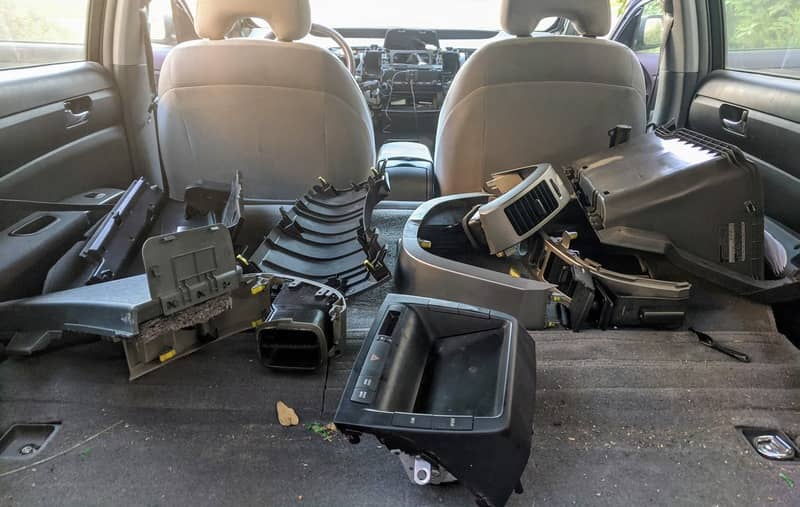 The backseat with the various remains of the dashboard in perfectly chaotic order.