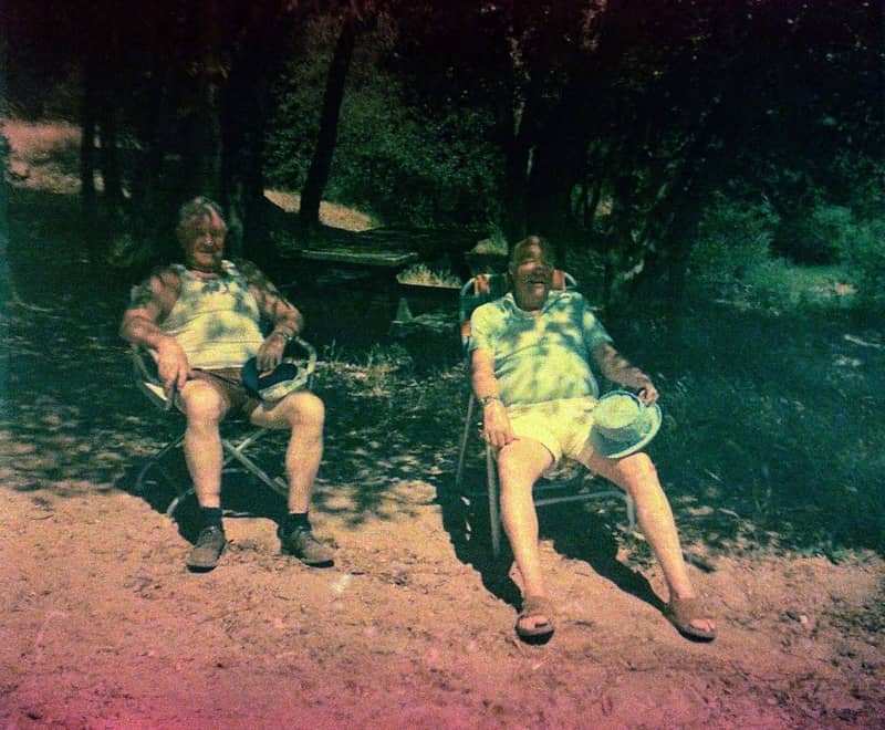 Found Film: two old men sit under a tree on and appear overheated.