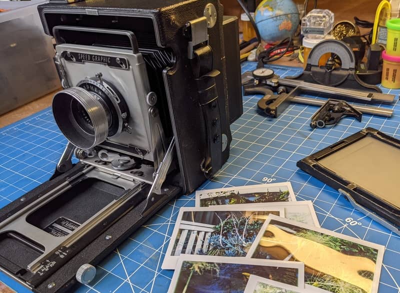 My Speed Graphic sits next to test shots from the LomoGraflok on the work bench.