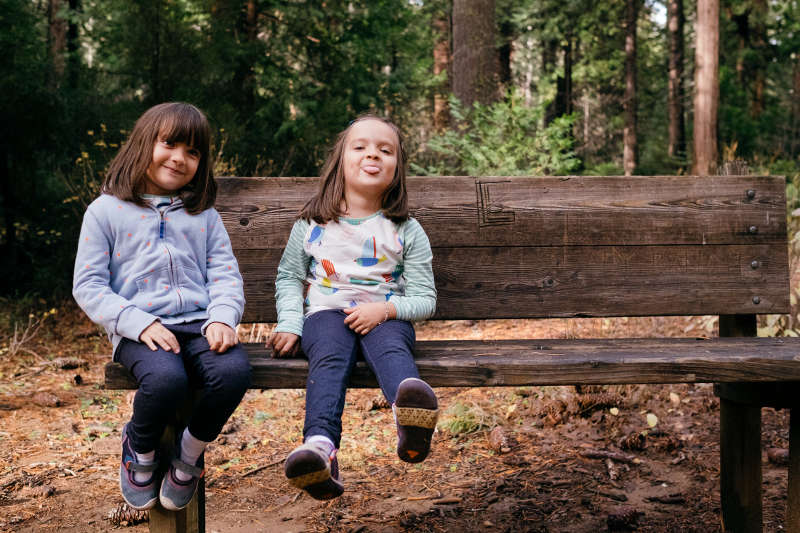 My daughters Eve (left) and Bell (right) sitting on a bench at Calaveras Big Trees State Park in California