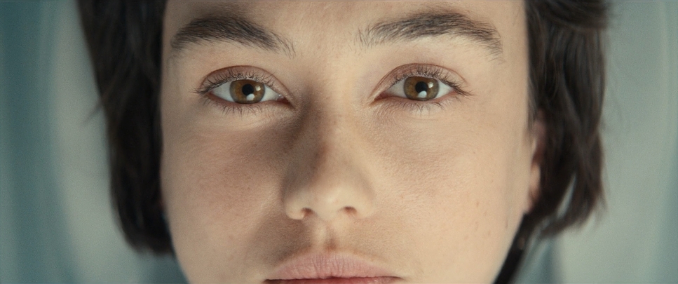 Demetria looks directly at the listener, her face and dark hair filling the widescreen portrait.