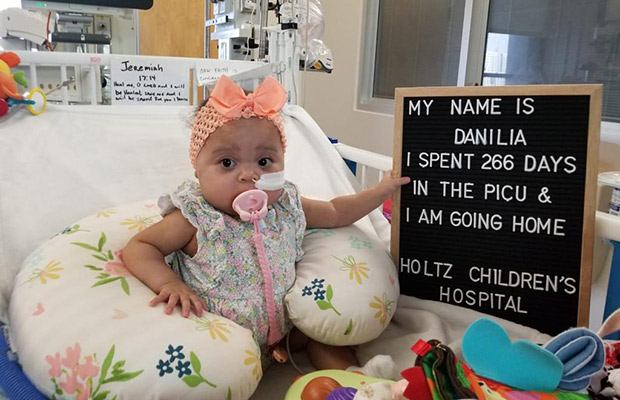 Baby with a sign that says she is going home