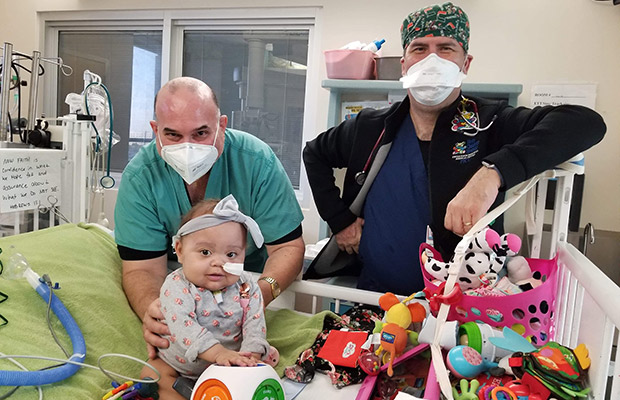 Baby at the hospital with two physicians near her