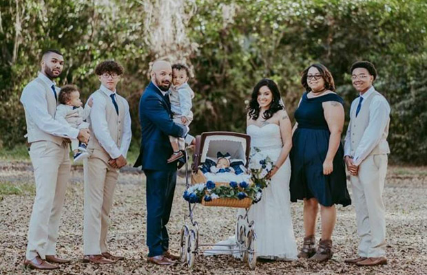 A wedding party outdoors with a baby in a stroller