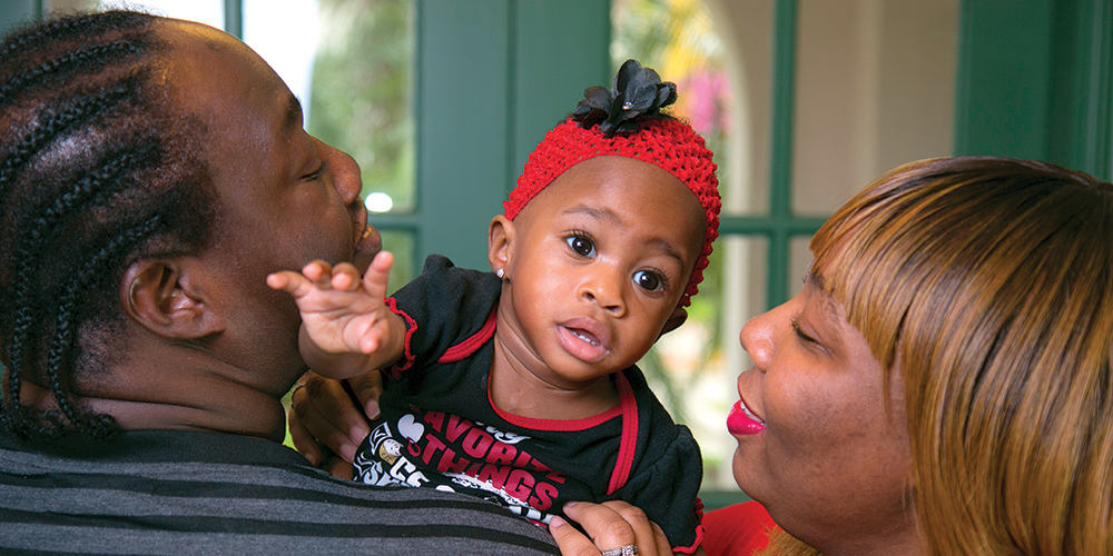 Symphony being held by her mom and dad