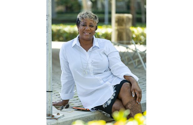 Karen Hunter sitting outdoors and smiling at the camera