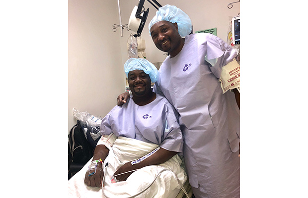 Two man in hospital scrubs, they are smiling and looking at the camera