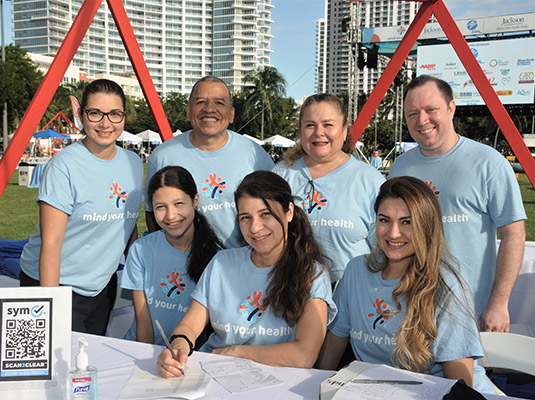 A group of people looking at the camera, they all have on mind your health shirts