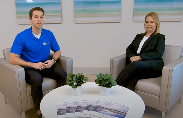 A man and woman sitting on separate couches for an interview, they both look at the camera