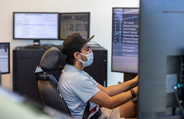 A closeup of a man behind the wheel of a driving simulator