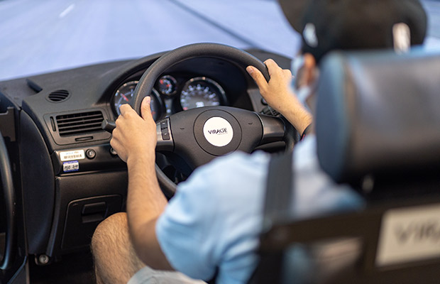 A closeup of a man behind the wheel of a driving simulator