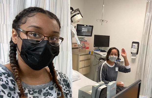 Two women in a hospital suite, they have on masks and are looking at the camera