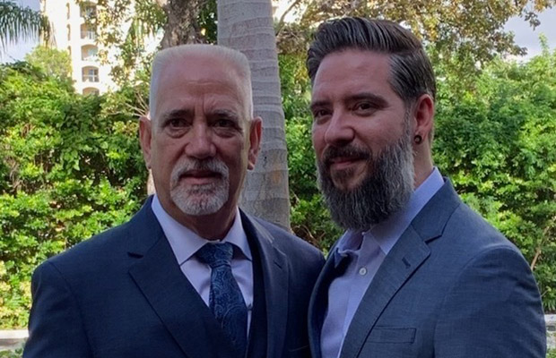 Two man in suits, they're standing outdoors and looking at the camera