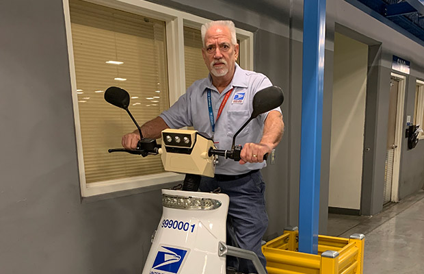 A middle aged man wearing his work attire and standing on a segway